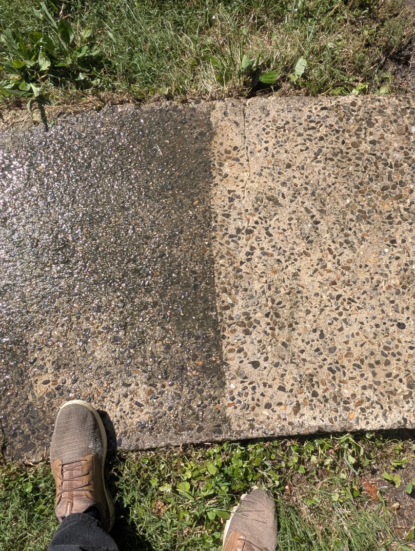 One concrete slab, wet cleaned half beside a dry half, shoes at the bottom of the frame.